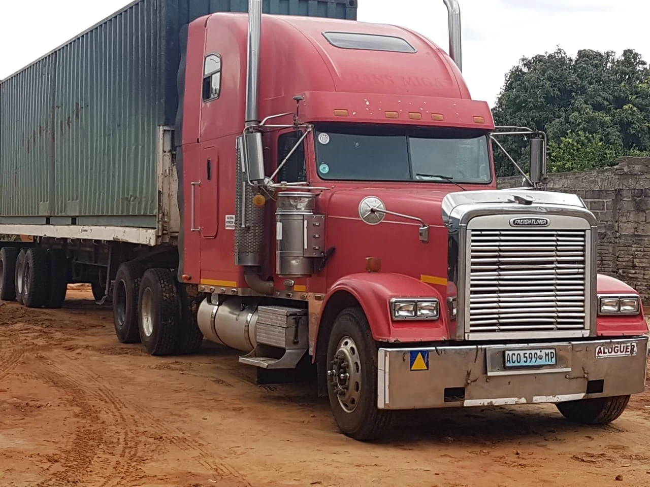 Camião Freightliner vermelho da Trans Migas com contentor